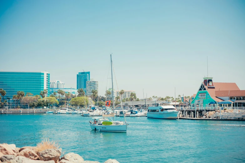 a number of boats in a body of water, by Ryan Pancoast, pexels contest winner, hurufiyya, long beach background, bright summer day, city of pristine colors, lachlan bailey