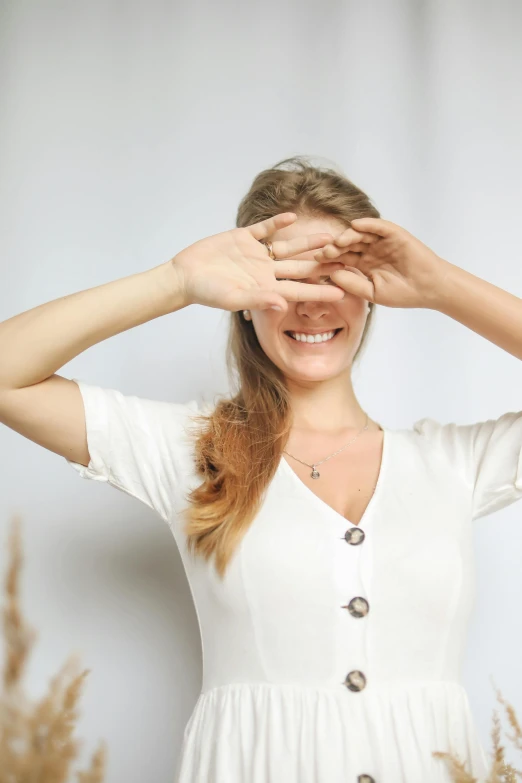 a woman covering her eyes with her hands, a picture, trending on pexels, renaissance, wearing a light shirt, happy fashion model face, cut out, white-space-surrounding