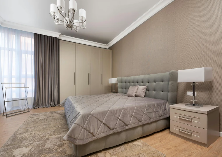 a bed room with a neatly made bed and a chandelier, a portrait, by Andries Stock, shutterstock, taupe, elegant wardrobe, designer furniture, on a cloudy day
