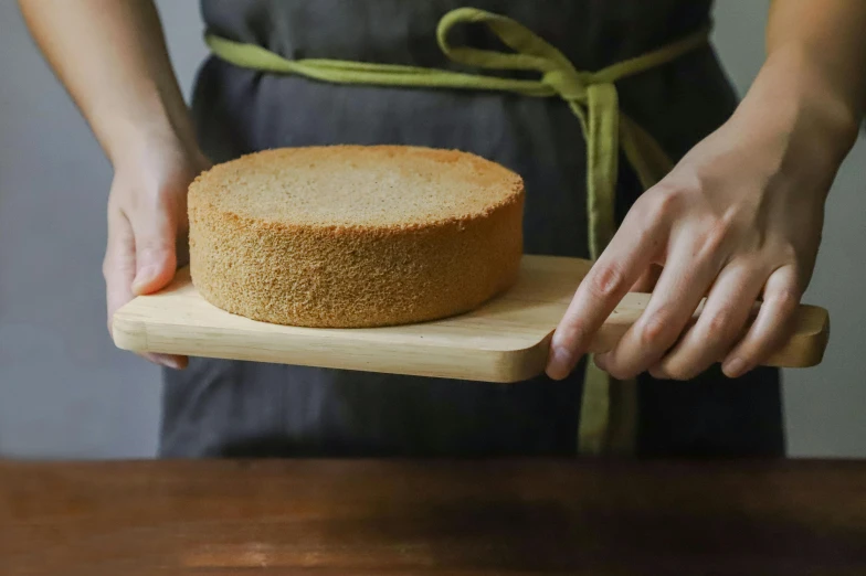 a close up of a person holding a cake on a cutting board, inspired by Richmond Barthé, trending on unsplash, john pawson, japanese collection product, levitating sand, round format