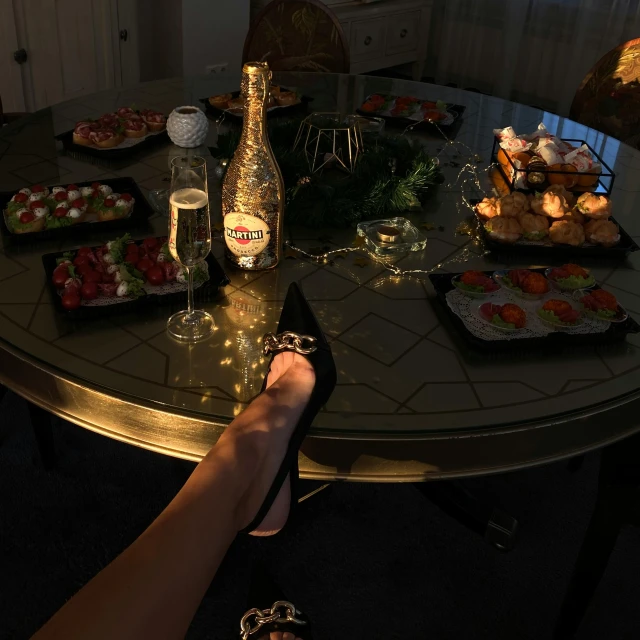 a person sitting at a table with a bottle of champagne, a picture, high heels, food pov, during the night, profile image