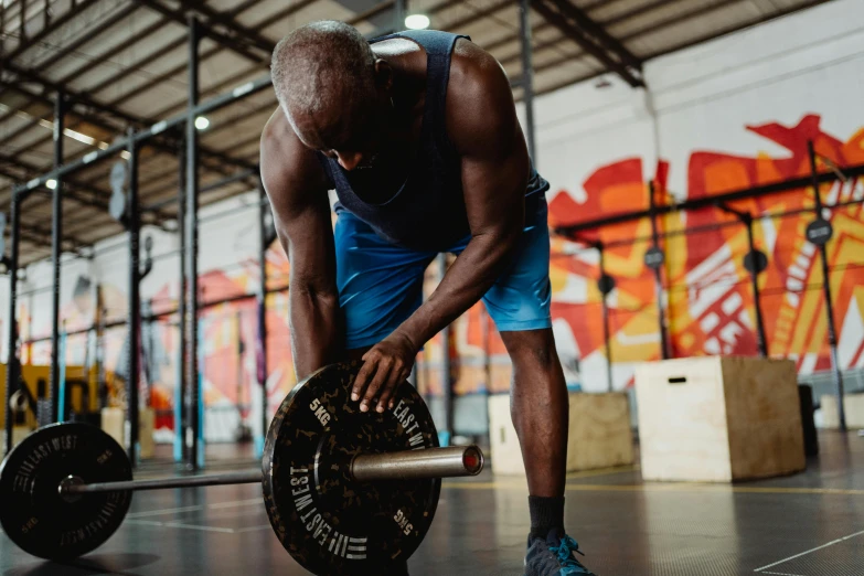 a man lifting a barbell in a gym, pexels contest winner, emmanuel shiru, head down, avatar image, lachlan bailey