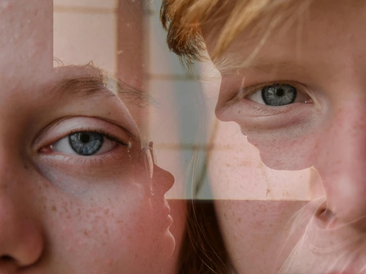 a girl looking at her reflection in a mirror, an album cover, by Kristian Zahrtmann, trending on pexels, hyperrealism, red haired teen boy, grid montage of eyes, with freckles, two girls
