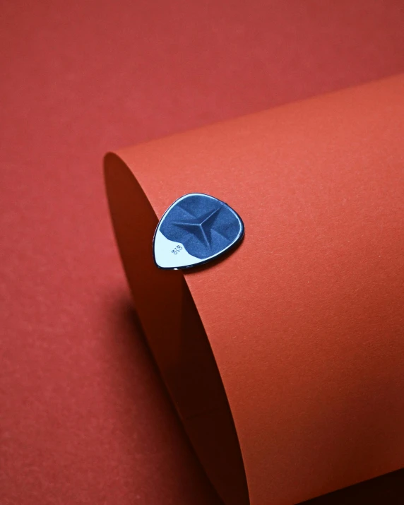 a guitar pick sitting on top of a piece of paper, aeroplane, detailed product image, blue steel, detail shot