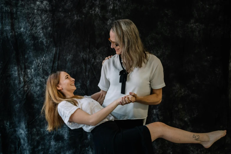 a man and a woman standing next to each other, pexels contest winner, antipodeans, smiling and dancing, daughter, in a photo studio, woman holding another woman