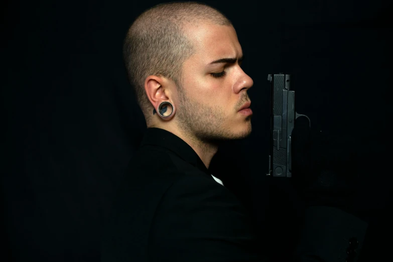 a man with a gun in his hand, a character portrait, pexels contest winner, shaved sides, headshot profile picture, beskinski, ariel perez