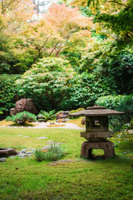 a stone lantern sitting on top of a lush green field, inspired by Tōshi Yoshida, beautiful garden, seattle, a wooden