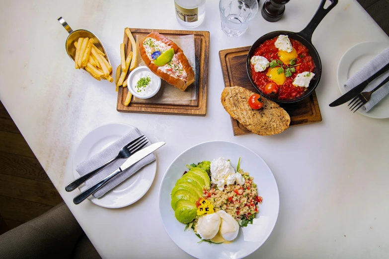 a table topped with plates of food and silverware, braavos, birdeye, city view, flatlay