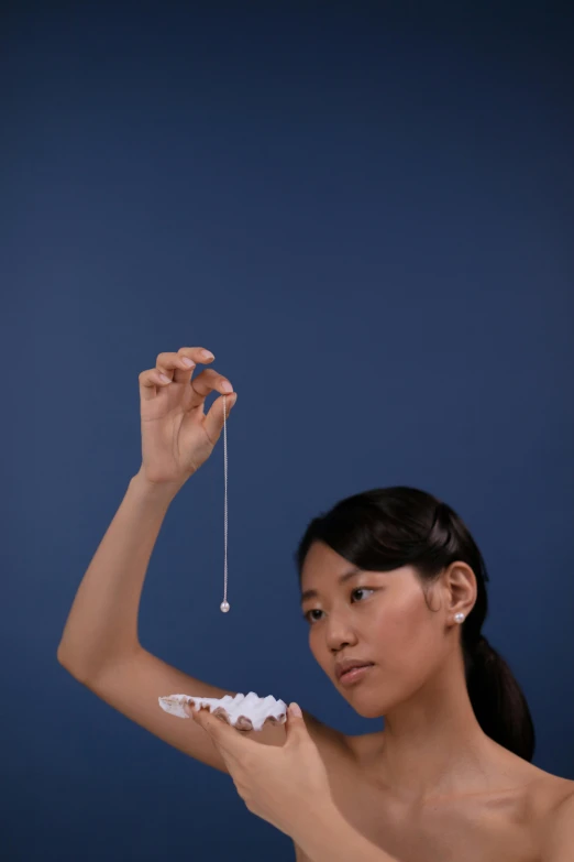 a woman holding a piece of cake in front of her face, inspired by Fei Danxu, kinetic art, jewelry pearls, holding scale, product lighting, photographed for reuters