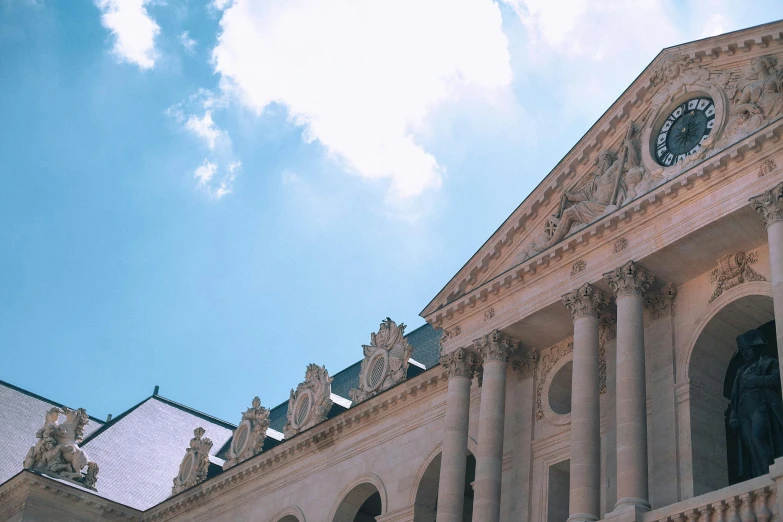 a large building with a clock on the front of it, inspired by Stanislas Lépine, pexels contest winner, neoclassicism, light blue sky with clouds, view from bottom, buttresses, grand library