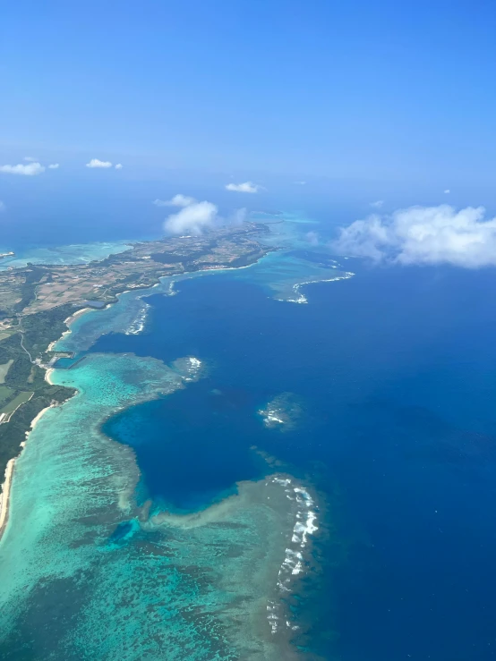 an aerial view of an island in the middle of the ocean, okinawa japan, slide show, carson ellis, blue skies