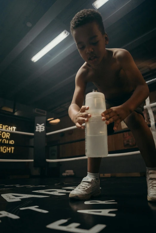 a young man sitting on top of a boxing ring, by Jacob Toorenvliet, pexels contest winner, transhumanist hydration, light over boy, gif, working out