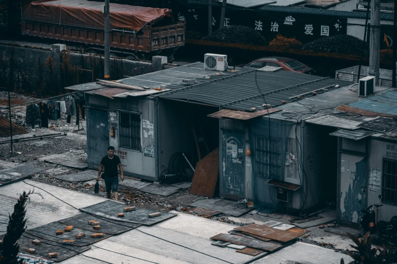 a man standing on top of a roof next to a building, a detailed matte painting, pexels contest winner, realism, shipping containers, kowloon walled city style, iron and asphalt, buildings covered in black tar