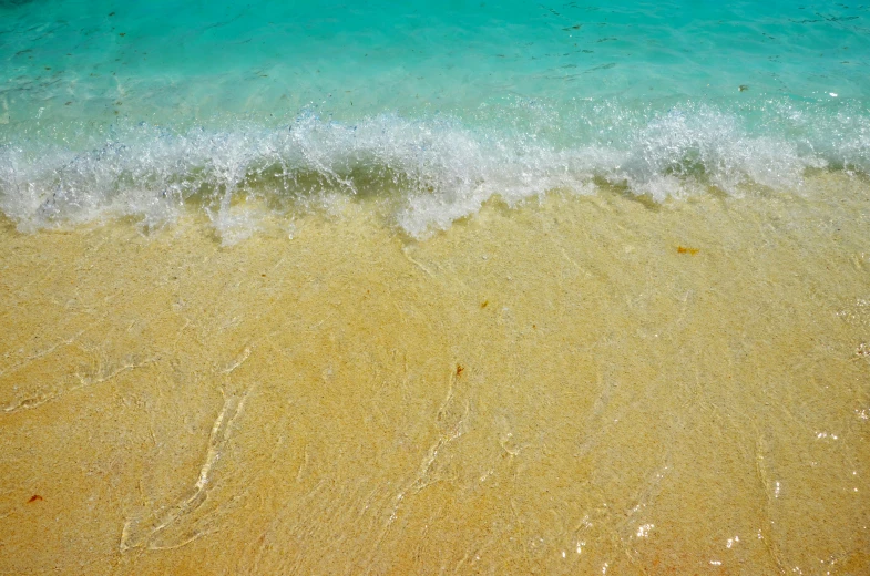 a large body of water next to a sandy beach, an album cover, pexels contest winner, carribean turquoise water, turbulent water, yellow and blue and cyan, carribean white sand