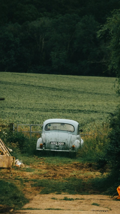 an old car parked on the side of a dirt road, pexels contest winner, renaissance, 35mm 1990, northern france, low quality photo, digital image