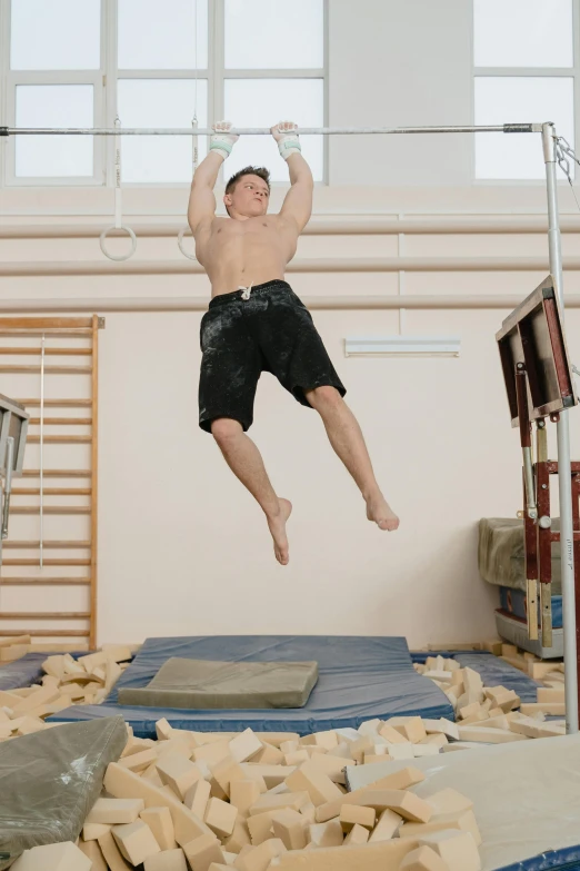 a man jumping in the air on a trampoline, by Ilya Ostroukhov, happening, of a muscular, in a workshop, buff, adam ondra