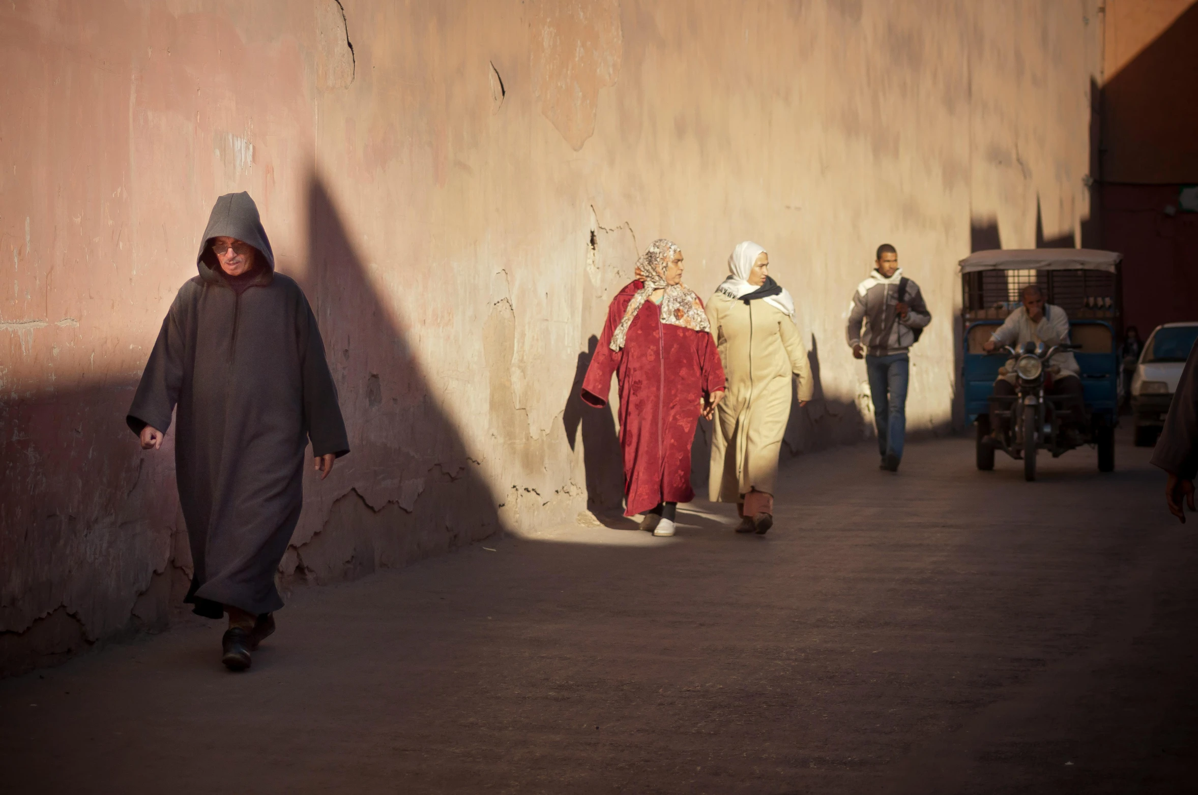 a group of people walking down a street, a photo, inspired by Alberto Morrocco, les nabis, red robes, morning light, wearing long silver robes, february)