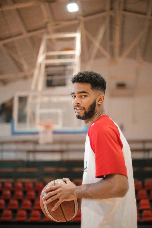 a man in a red and white shirt holding a basketball, by Frank Mason, trending on dribble, headshot profile picture, ashteroth, basketball court, indoor picture