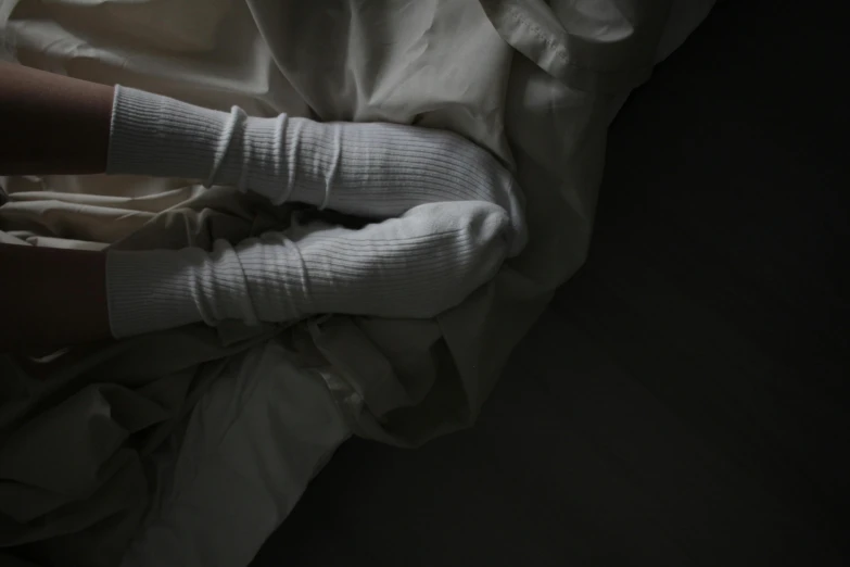 a person laying in bed wearing white socks, inspired by Elsa Bleda, massurrealism, faceless people dark, white sleeves, intertwined full body view, silver，ivory