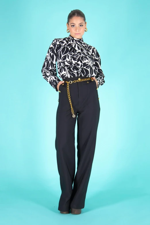 a woman standing in front of a blue background, black trousers, vintage shirt, gold chain belt, detailed product image