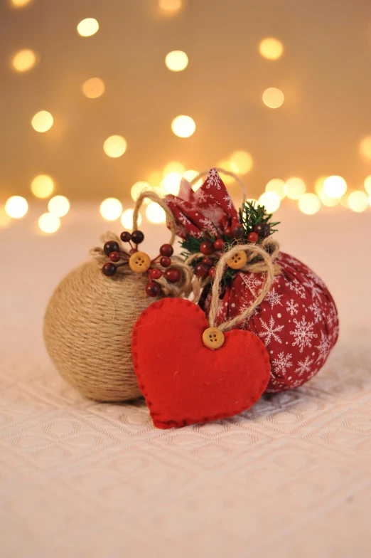 a couple of ornaments sitting on top of a bed, burlap, dressed in red paper bags, bountiful crafts, full product shot