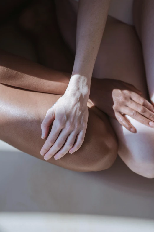 a woman sitting on top of a white bath tub, inspired by Vanessa Beecroft, trending on unsplash, massurrealism, holding each other hands, thighs close up, sun flares, ignant