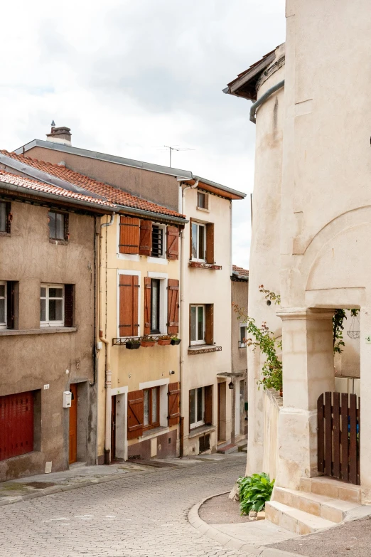 a couple of buildings that are next to each other, inspired by Pierre Brissaud, pexels contest winner, romanesque, beige, neighborhood, villeneuve, view from back