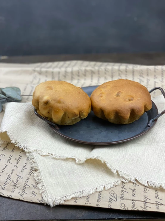 a close up of a plate of food on a table, brown hair in two buns, dough sculpture, antiqued look, medium wide front shot