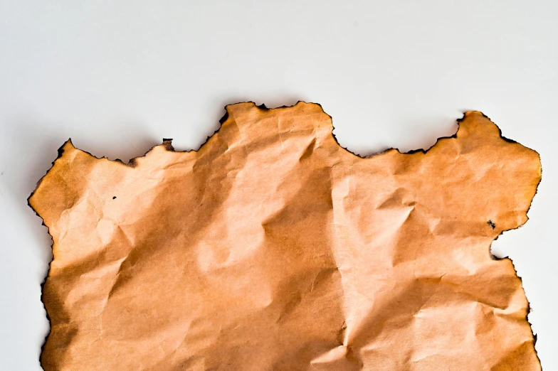 a piece of brown paper sitting on top of a table, by Simon Gaon, trending on pexels, minimalism, bark for skin, background image, cover image, glazed