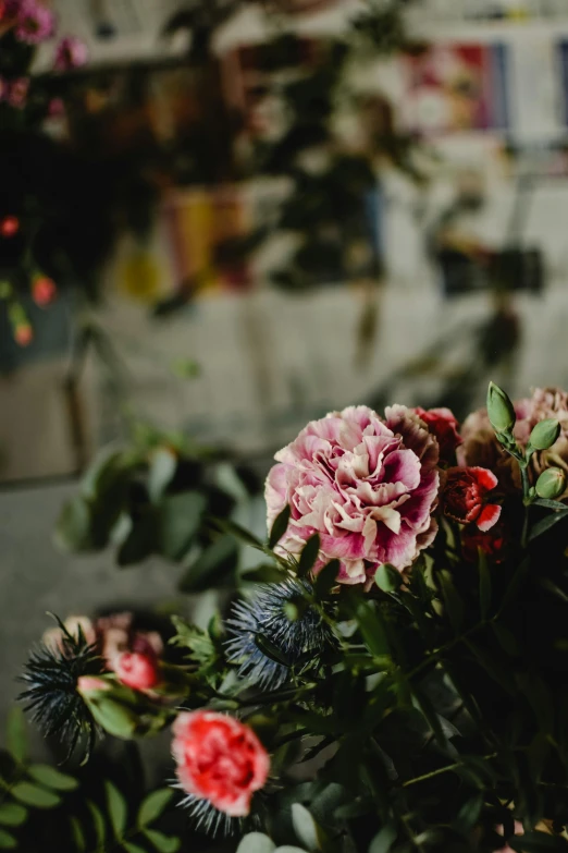 a bunch of flowers sitting on top of a table, by Elsie Few, trending on unsplash, renaissance, festive, in bloom greenhouse, moody details, carnation