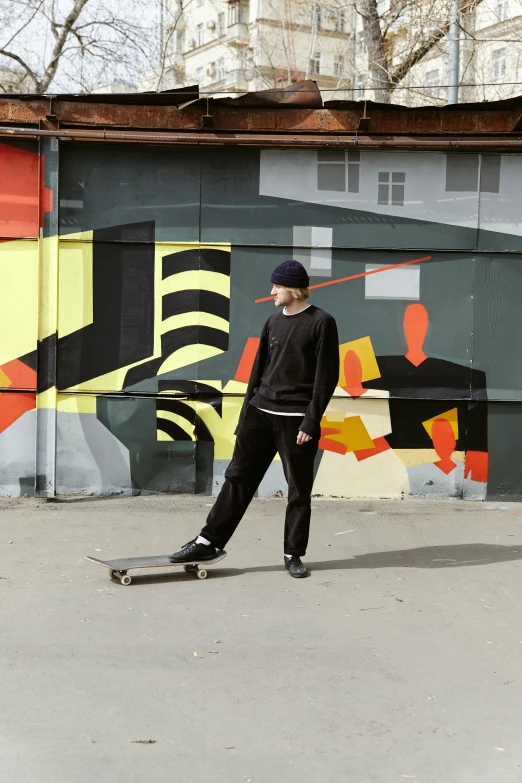 a man riding a skateboard down a street, a cartoon, by Attila Meszlenyi, pexels contest winner, street art, casual black clothing, neo rauch and nadav kander, ( ( bauhaus ) ), in front of a garage