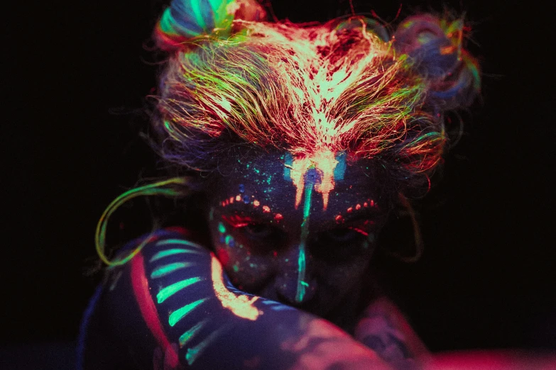 a close up of a person with paint on their face, cyberpunk art, inspired by Elsa Bleda, trending on pexels, art photography, glowing hair, photograph of three ravers, luminous veins, tribal paint