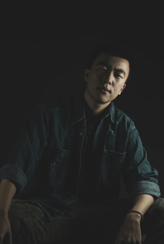 a man sitting on a chair in the dark, an album cover, inspired by Huang Gongwang, unsplash, mid portrait, low quality grainy, portrait of tall, sittin