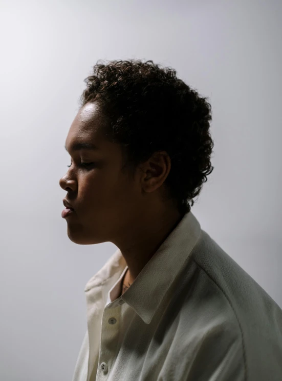 a man in a white shirt smoking a cigarette, by Winona Nelson, mixed race woman, side profile view, non binary model, tessa thompson