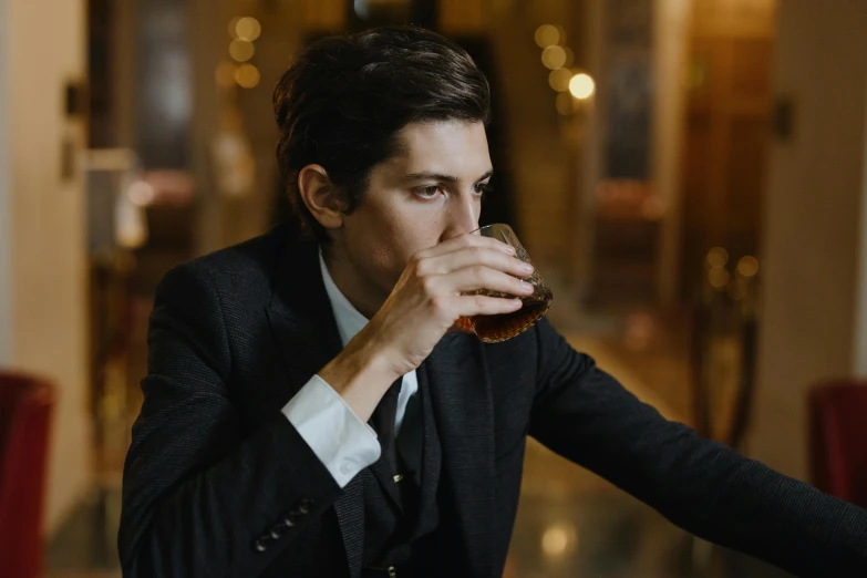 a man in a suit drinking from a glass, by Emma Andijewska, pexels contest winner, renaissance, adam driver, drinks bourbon, declan mckenna, profile image