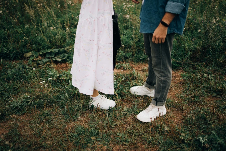 a man and a woman standing next to each other in a field, pexels contest winner, wearing white sneakers, childish look, social encounters, in the garden