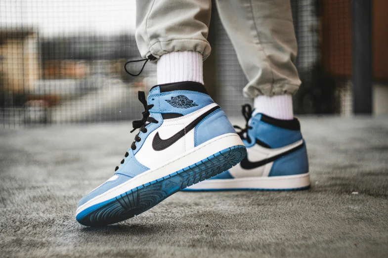 a person wearing a pair of blue and white sneakers, inspired by Jordan Grimmer, trending on unsplash, air jordan 1 high, blue rim light, blue and black, thumbnail