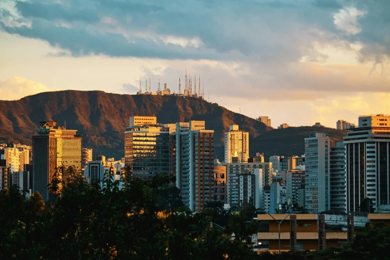 a view of a city with a mountain in the background, by Alejandro Obregón, pexels contest winner, helio oiticica, golden hour photograph, panoramic, outdoors tropical cityscape