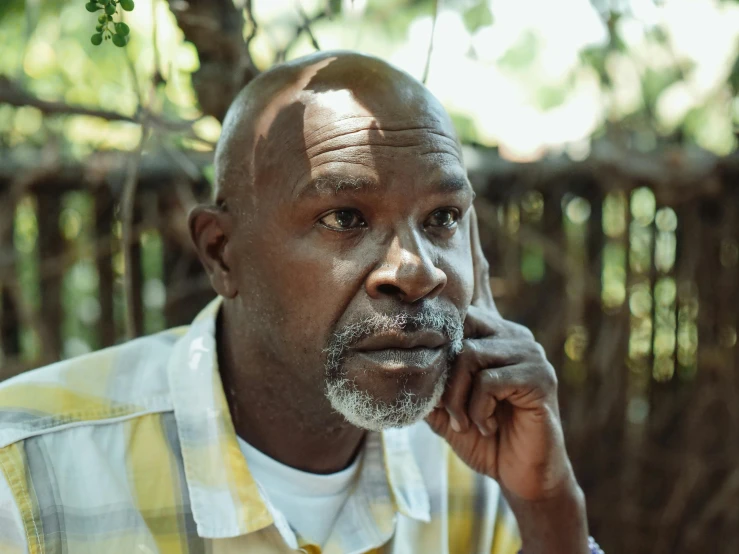 a close up of a person talking on a cell phone, a portrait, pexels contest winner, hurufiyya, photo of a 50-year-old white man, emmanuel shiru, sitting in the garden, 15081959 21121991 01012000 4k