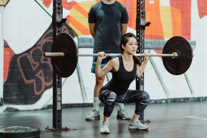 a woman squatting with a barbell in a gym, pexels contest winner, jin shan and ross tran, standing in midground, sydney park, 4 legs