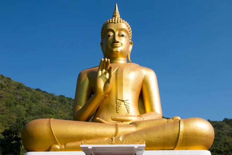 a large golden buddha statue sitting on top of a white pedestal, a statue, blue, avatar image, new zealand, thai architecture