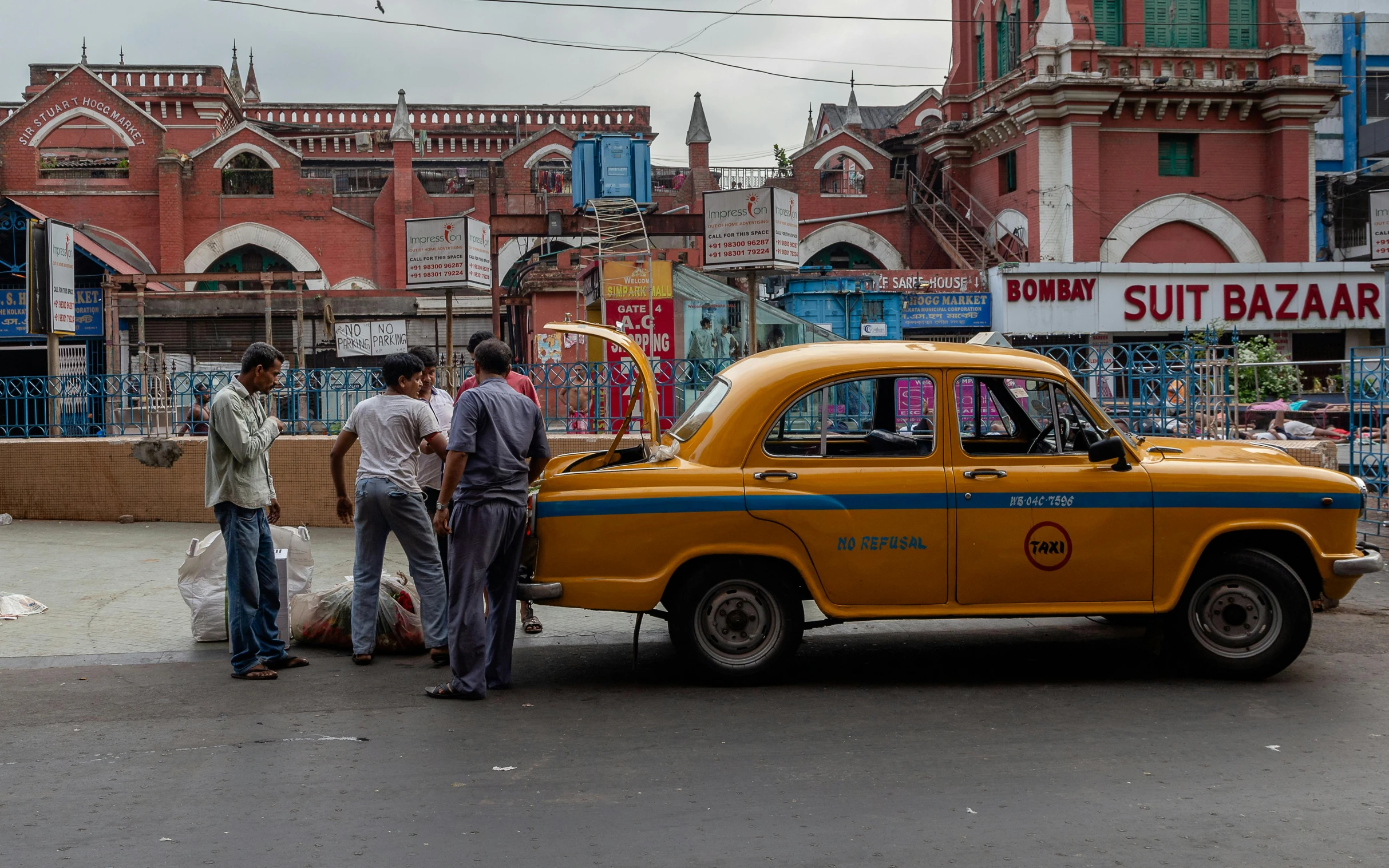 a couple of men standing next to a yellow taxi, pexels contest winner, bengal school of art, busy market, intersection, dezeen, square