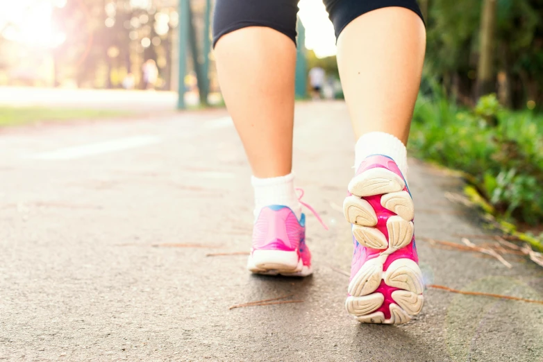 a close up of a person walking on a sidewalk, running shoes, pink, a park, te pae