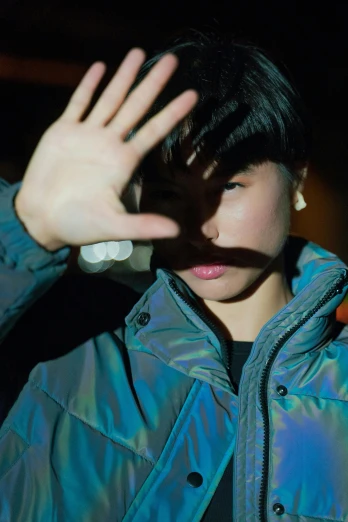 a close up of a person wearing a jacket, inspired by Zhu Da, unsplash, iridescent image lighting, waving at the camera, young boy, mei-ling zhou