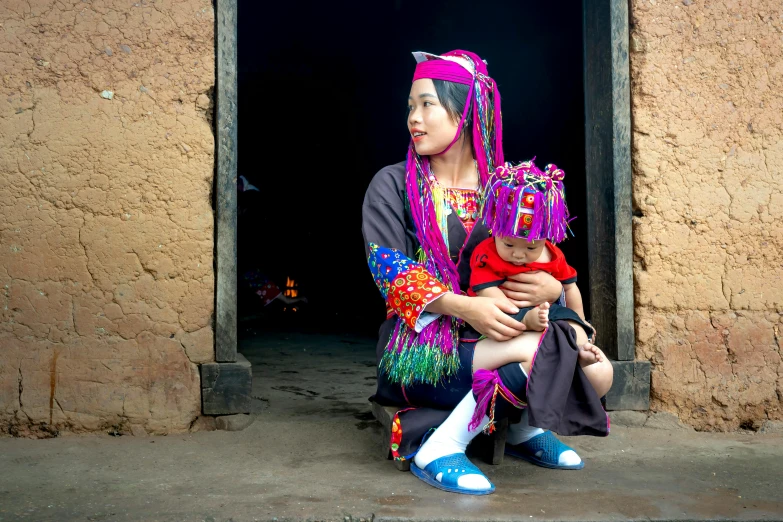 a woman holding a child in front of a doorway, inspired by Hu Zao, pexels contest winner, colorful pigtail, larapi, colorful”