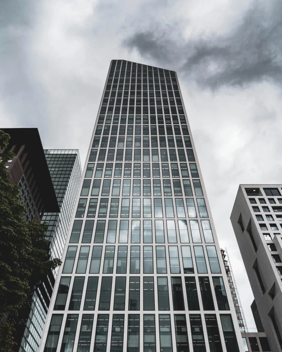 a tall building sitting in the middle of a city, overcast gray skies, marketing photo, thumbnail, arasaka