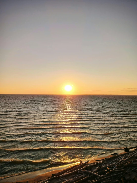 the sun is setting over the water at the beach, a picture, pexels contest winner, album cover, low quality photo, crisp lines, view of sea