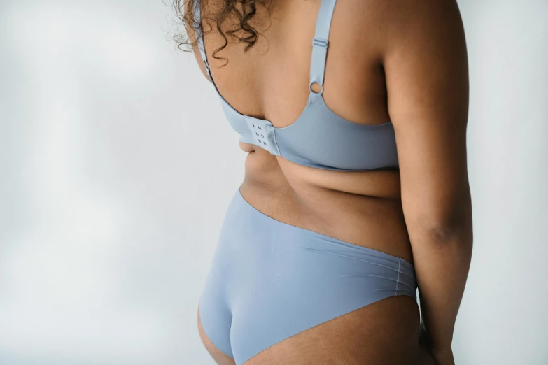 a close up of a woman in a blue underwear, unsplash, blue and gray colors, view(full body + zoomed out), curved, slightly overweight