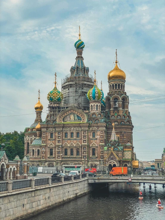 a large building next to a body of water, a colorized photo, inspired by Vasily Surikov, pexels contest winner, baroque, with great domes and arches, brown and cyan color scheme, cinematic”