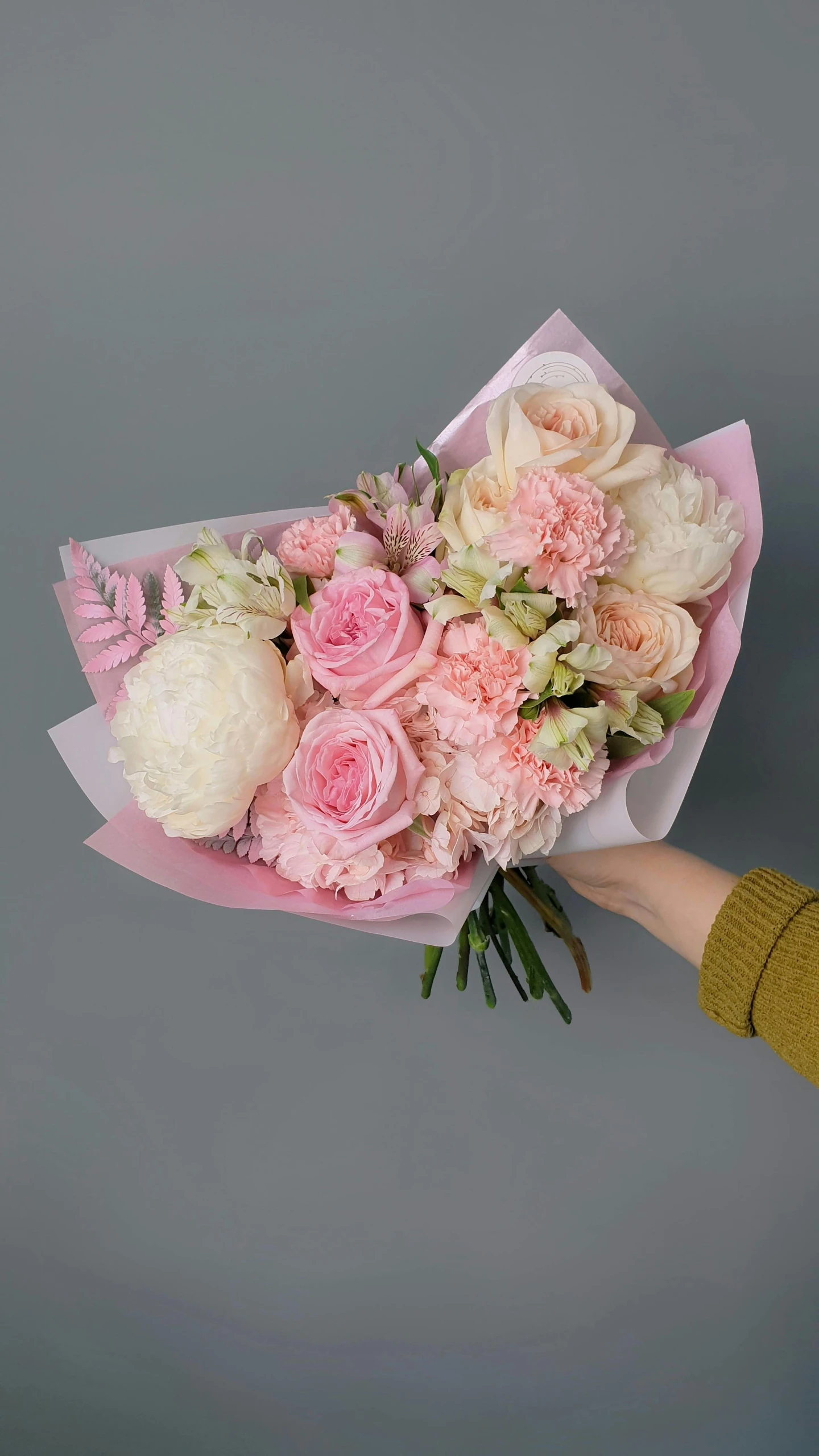 a woman holding a bouquet of pink and white flowers, a pastel, inspired by François Boquet, pexels, on grey background, sweet hugs, flower shop scene, carnation